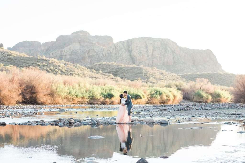 A man and a woman are standing in the water wondering what to wear.