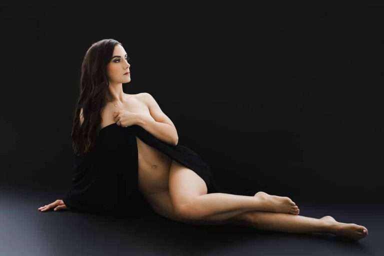 A woman posing in black for boudoir photography.