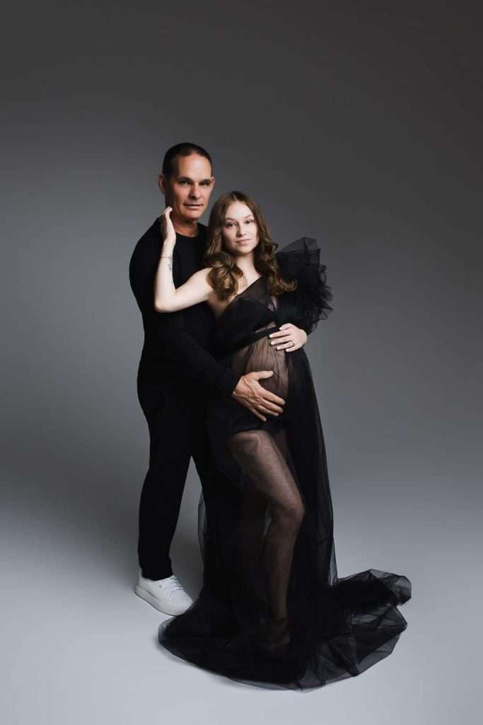 A pregnant man and woman posing for a photo.