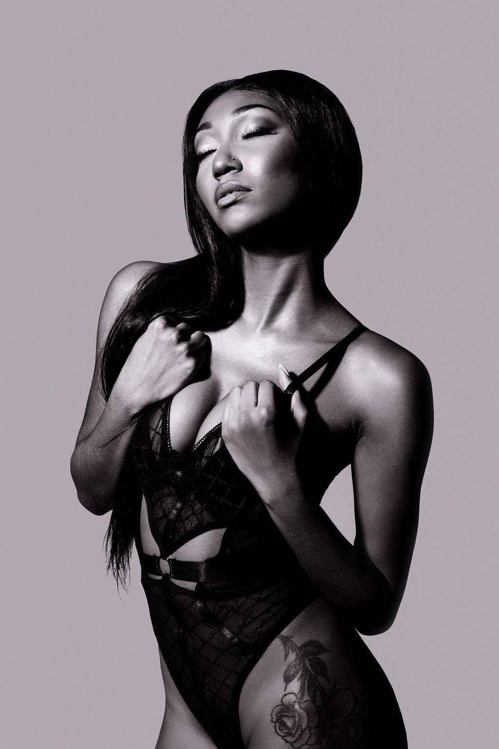 luxury boudoir A monochrome portrait of a woman in lingerie posing with her head tilted upwards.