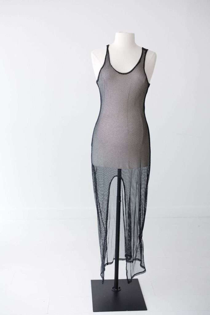 A black, sleeveless, sheer mesh dress displayed on a white mannequin against a plain white background.