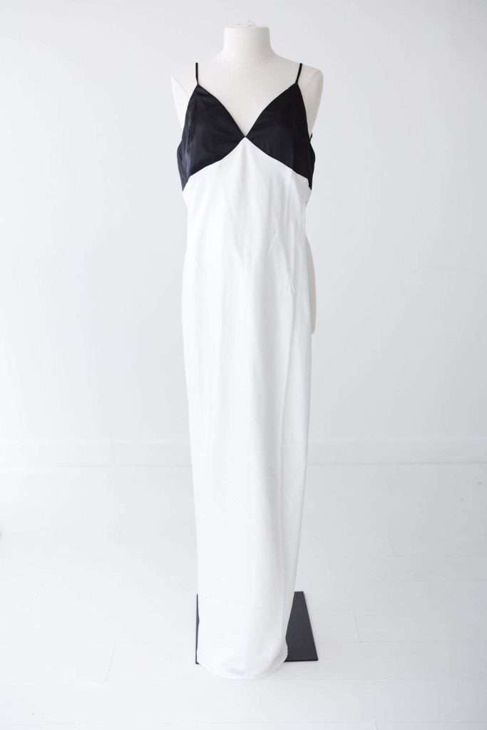 A sleeveless black and white color-blocked maxi dress displayed on a dress form against a plain white background.