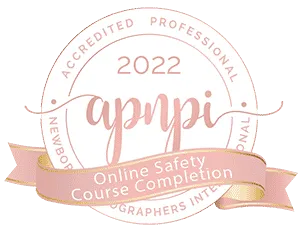 A round badge with "2022 APNPI Accredited Professional Newborn Photographers International" and a ribbon reading "Online Safety Course Completion.