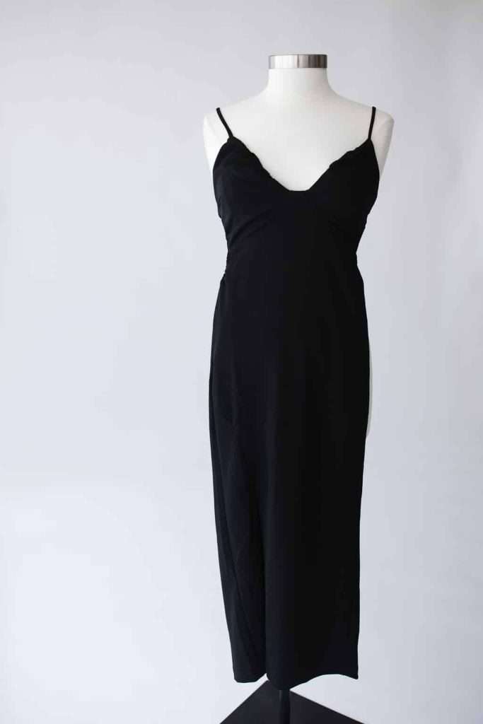 Black sleeveless slip dress with spaghetti straps displayed on a white mannequin against a plain background.