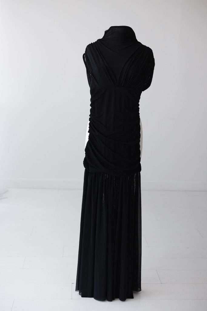 A sleeveless, floor-length black dress displayed on a mannequin, photographed from the back against a plain white background.