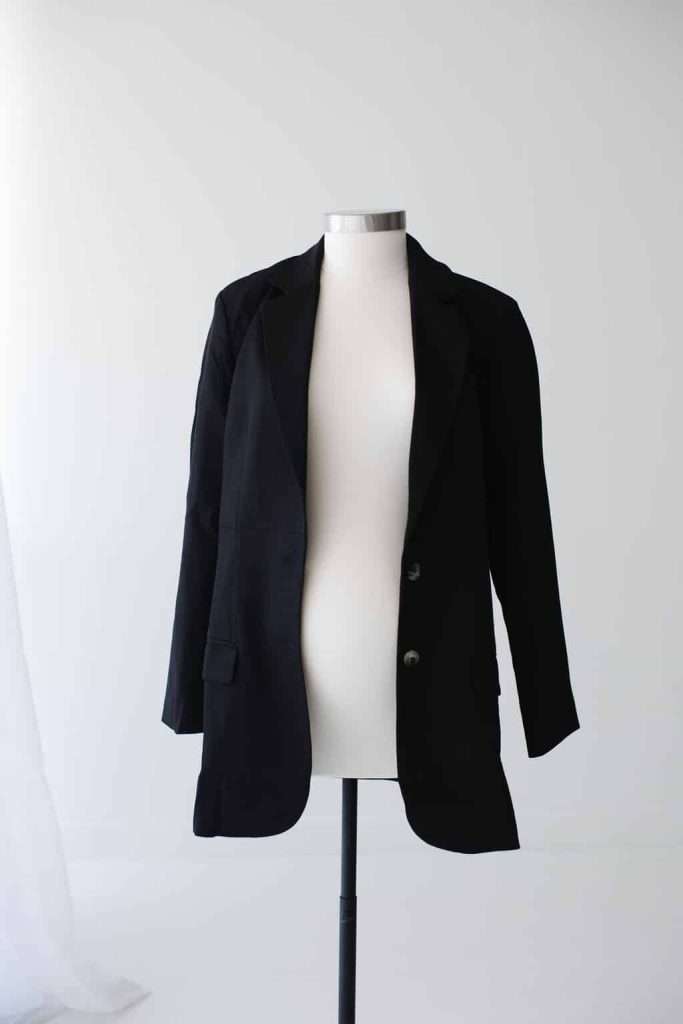 A black blazer displayed on a white dress form against a plain white background.