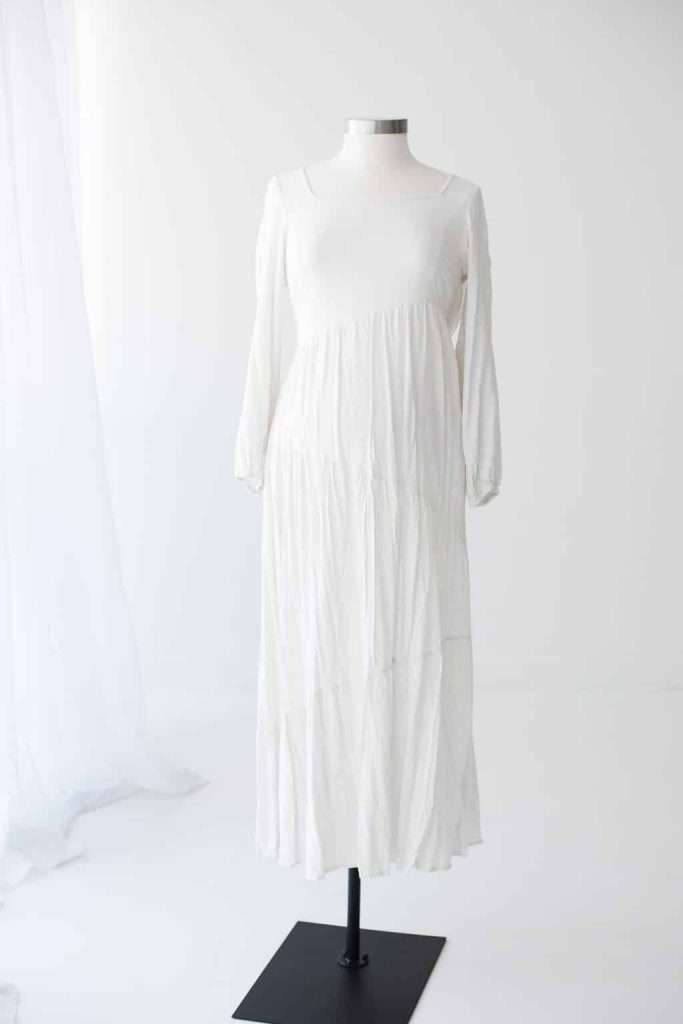 Long-sleeved white maxi dress displayed on a dress form against a plain white background.