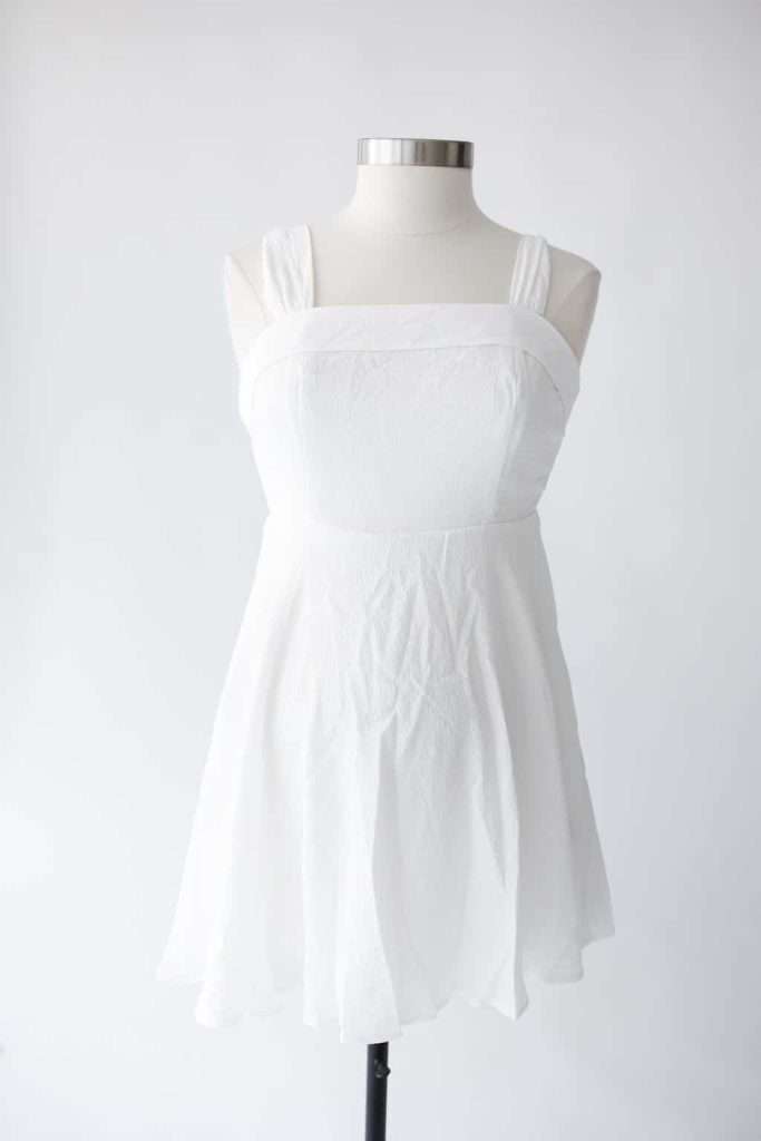 Sleeveless white dress with a square neckline displayed on a dress form against a plain white background.