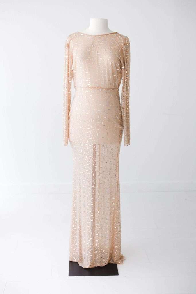 Long-sleeve, floor-length, nude-colored gown with geometric sequin pattern displayed on a white mannequin against a plain white background.