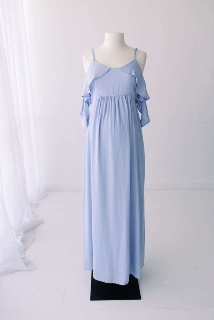 Light blue, sleeveless maxi dress with ruffled cold shoulder design displayed on a white mannequin against a plain white background.
