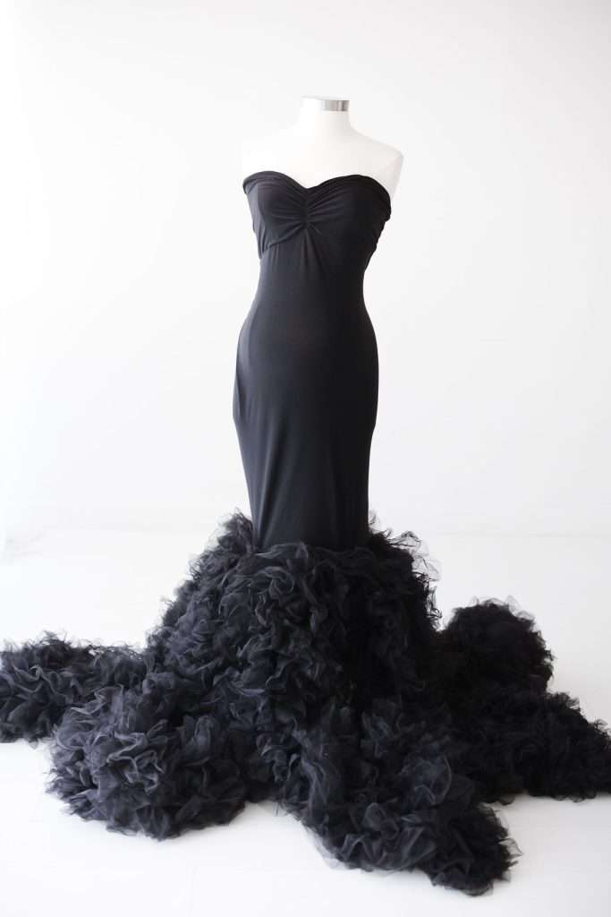Black strapless gown on a mannequin, featuring a fitted bodice and a voluminous tulle skirt that extends outwards at the bottom.